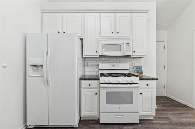 kitchen featuring backsplash, white cabinets, dark stone counters, dark wood-type flooring, and white appliances