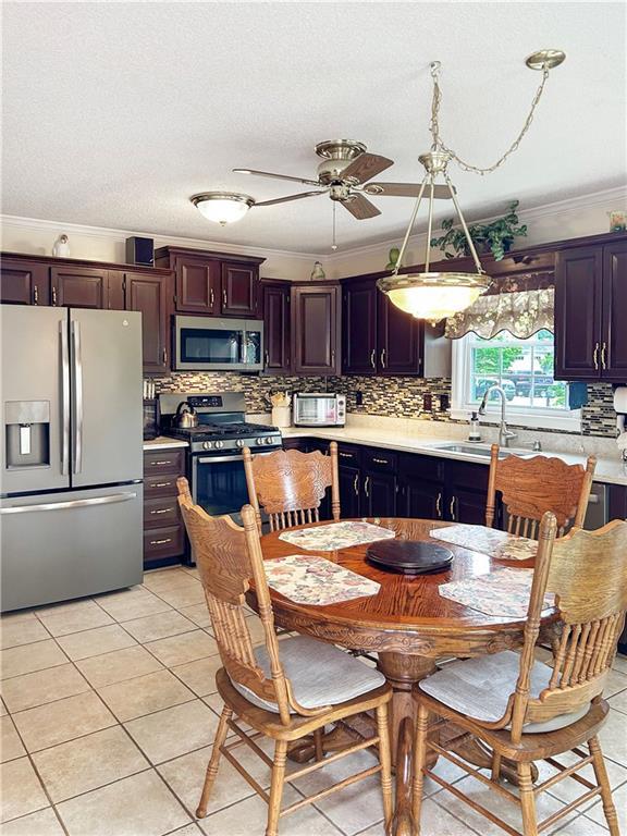 21 Picketts Ridge Ln, Acworth, GA 30101 - kitchen with stainless steel appliances, a sink, ornamental molding, light countertops, and backsplash
