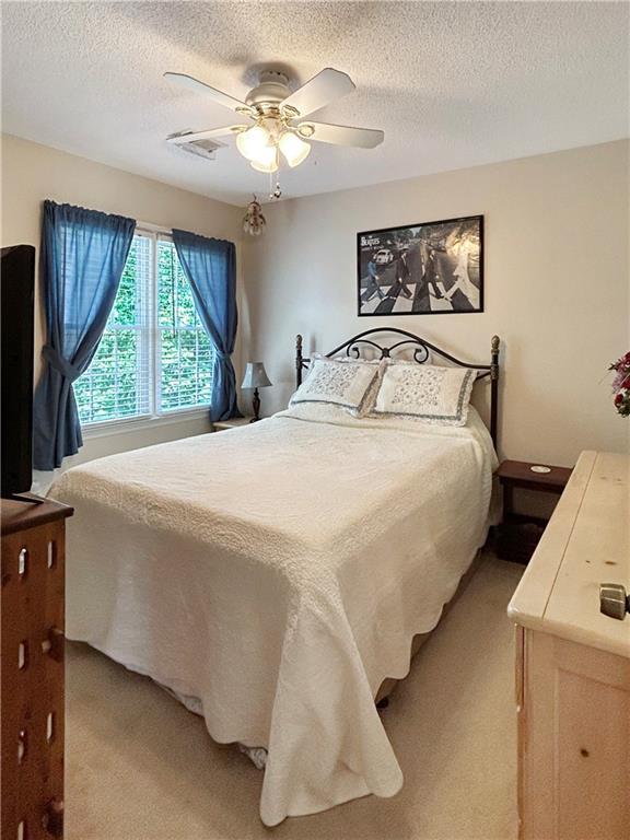 21 Picketts Ridge Ln, Acworth, GA 30101 - bedroom featuring light carpet, a textured ceiling, and ceiling fan