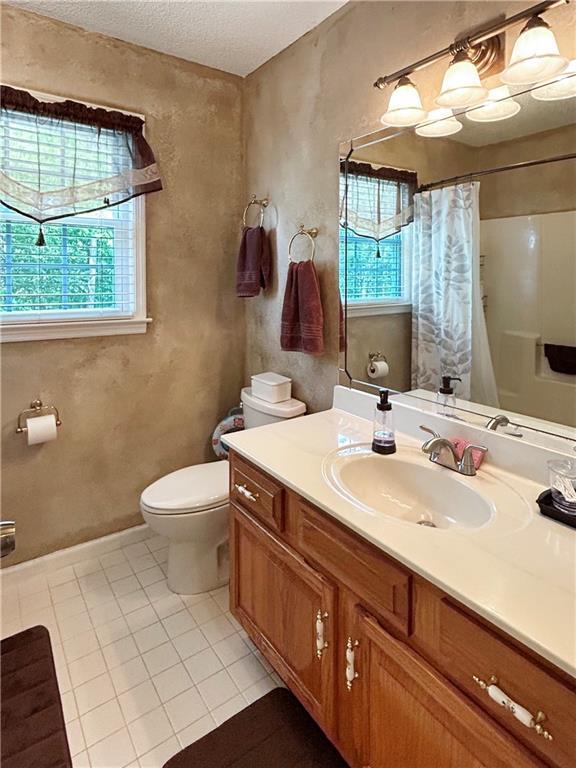 21 Picketts Ridge Ln, Acworth, GA 30101 - full bath featuring healthy amount of natural light, toilet, a shower with curtain, tile patterned floors, and a textured ceiling