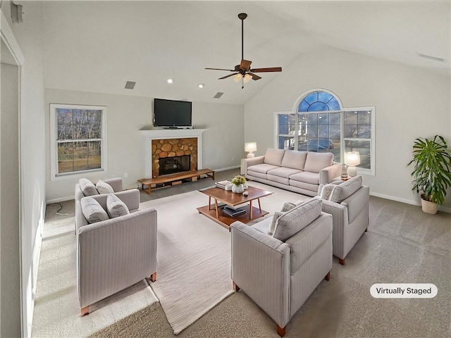 living room featuring baseboards, light colored carpet, ceiling fan, vaulted ceiling, and a stone fireplace