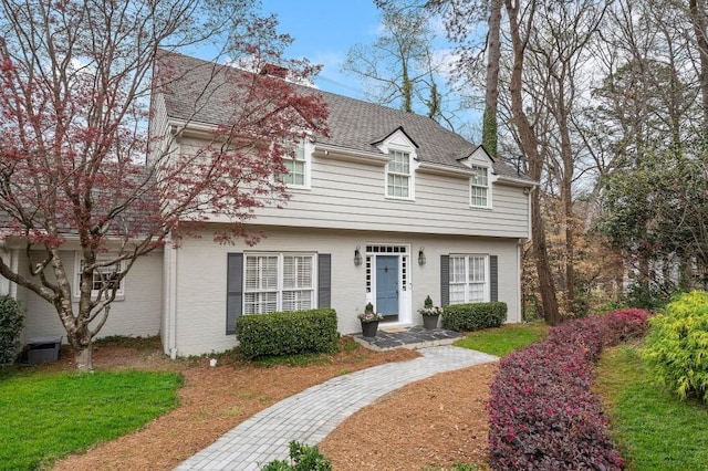 colonial inspired home with a shingled roof