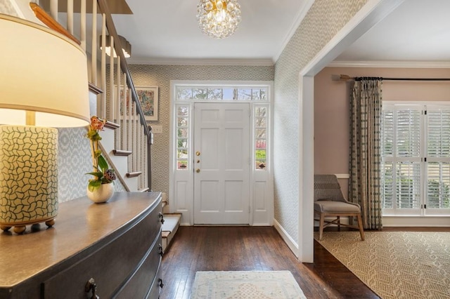 foyer with wallpapered walls, crown molding, stairway, and dark wood-type flooring