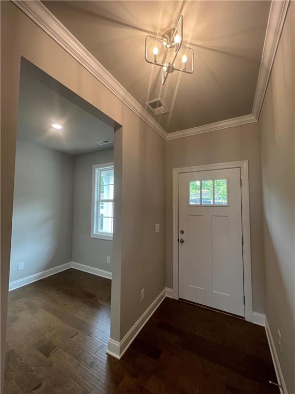 entryway featuring dark wood-type flooring, crown molding, and a chandelier