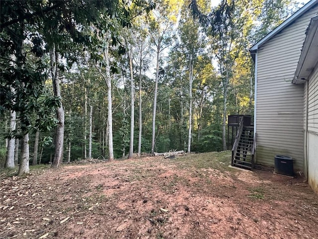 view of yard featuring a wooden deck and central air condition unit