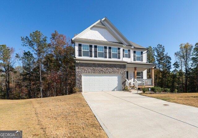 view of front facade with a garage, a porch, and a front lawn