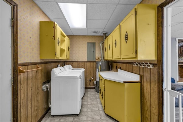 washroom featuring wallpapered walls, a wainscoted wall, gas water heater, cabinet space, and separate washer and dryer