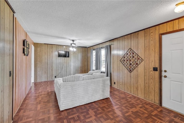 living area with a textured ceiling and wooden walls