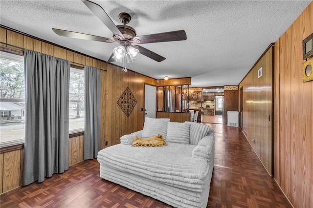 bedroom with wooden walls and a textured ceiling