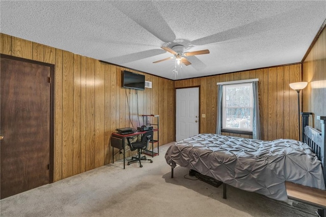 bedroom with wooden walls, a textured ceiling, a ceiling fan, and carpet floors