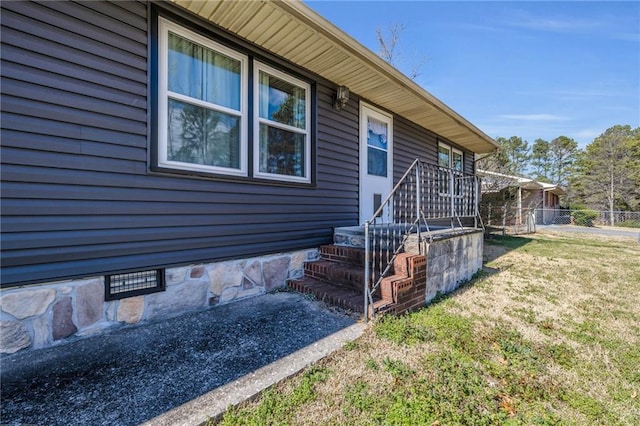 view of home's exterior with crawl space, a lawn, and fence