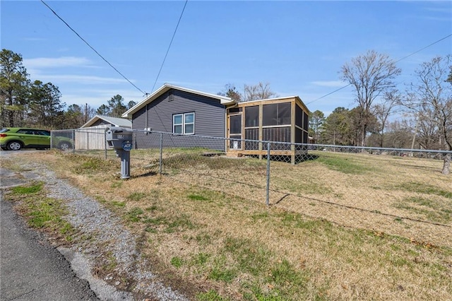 exterior space featuring driveway, fence, a yard, and a sunroom