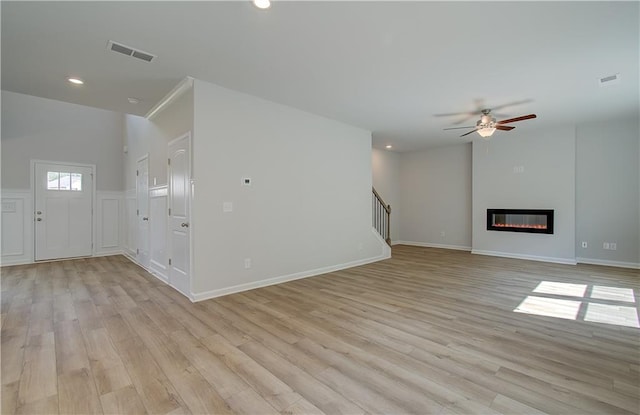 unfurnished living room featuring ceiling fan and light hardwood / wood-style floors