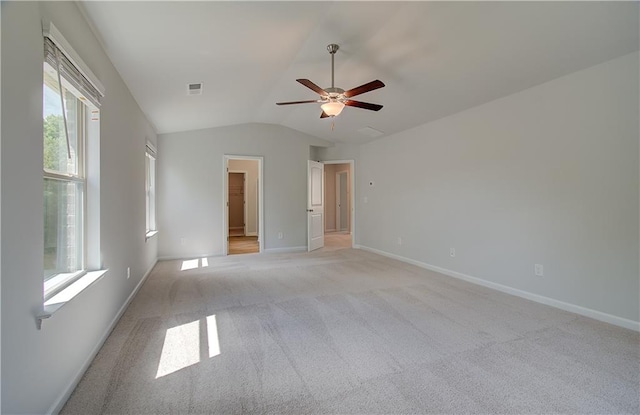 carpeted spare room featuring ceiling fan and vaulted ceiling