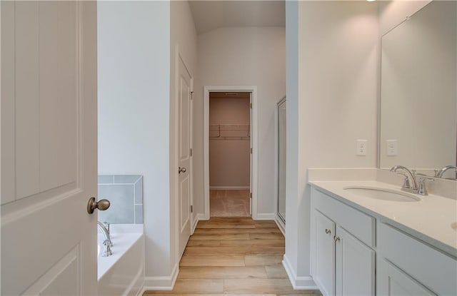 bathroom with vanity, wood-type flooring, and shower with separate bathtub