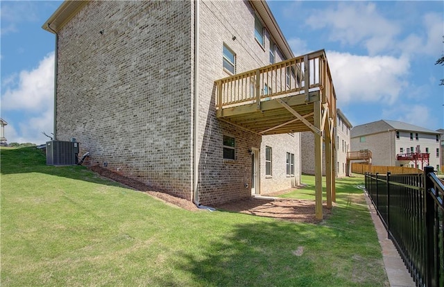 view of side of home featuring a lawn, cooling unit, and a wooden deck