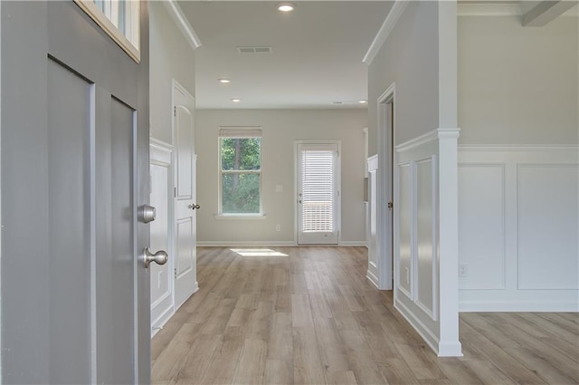 hallway featuring light wood-type flooring and crown molding