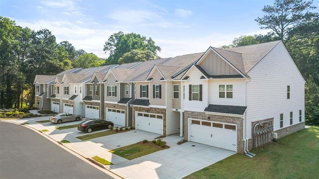 1317 Aura Ln, Lawrenceville, GA 30045 - townhome / multi-family property with board and batten siding, a garage, concrete driveway, a front lawn, and brick siding
