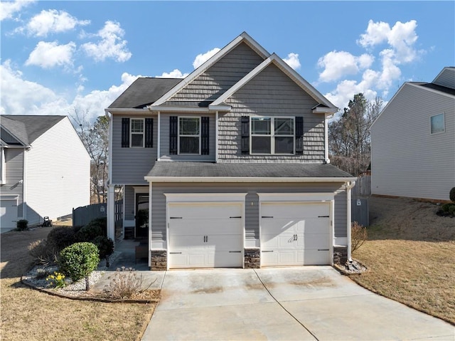 view of front of property featuring a garage, stone siding, and concrete driveway