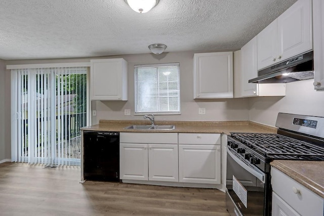 5295 Old Trail Cir, Stone Mountain, GA 30088 - kitchen featuring stainless steel gas range, under cabinet range hood, a sink, dishwasher, and light wood-type flooring
