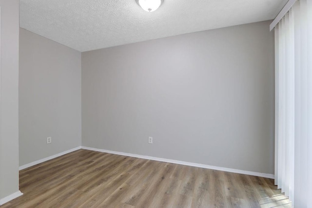 5295 Old Trail Cir, Stone Mountain, GA 30088 - spare room with wood finished floors, baseboards, and a textured ceiling