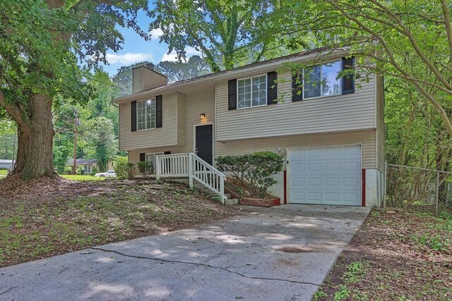 5295 Old Trail Cir, Stone Mountain, GA 30088 - split foyer home with a garage, a chimney, and driveway