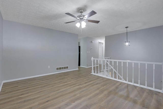 5295 Old Trail Cir, Stone Mountain, GA 30088 - spare room featuring wood finished floors, a textured ceiling, a ceiling fan, and baseboards