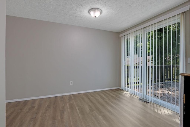 5295 Old Trail Cir, Stone Mountain, GA 30088 - spare room featuring wood finished floors, healthy amount of natural light, baseboards, and a textured ceiling