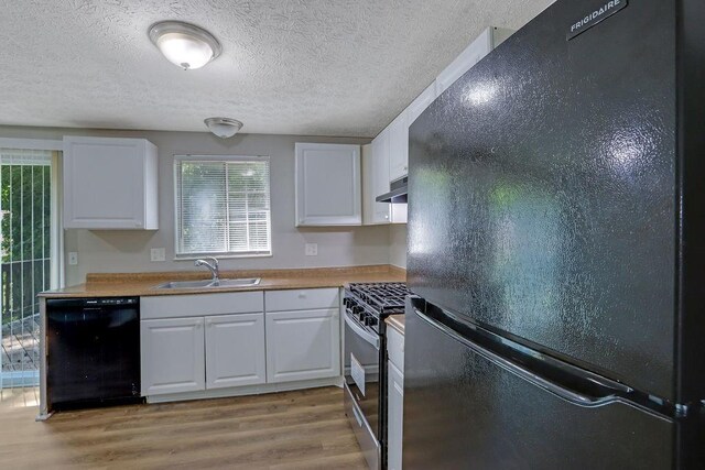 5295 Old Trail Cir, Stone Mountain, GA 30088 - kitchen featuring black appliances, a sink, under cabinet range hood, light wood-style flooring, and white cabinets