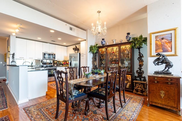 dining space featuring a chandelier and light wood-type flooring