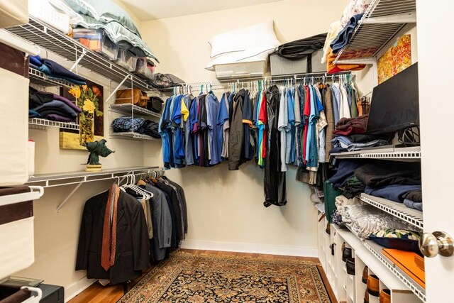 walk in closet with dark hardwood / wood-style floors