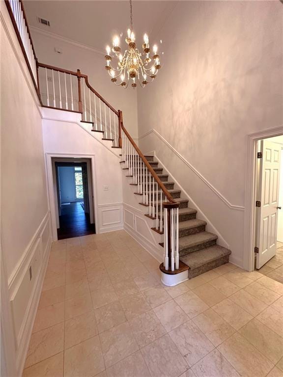 stairway featuring a high ceiling and a chandelier