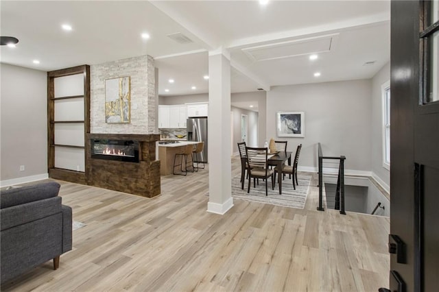 living room featuring a fireplace and light wood-type flooring