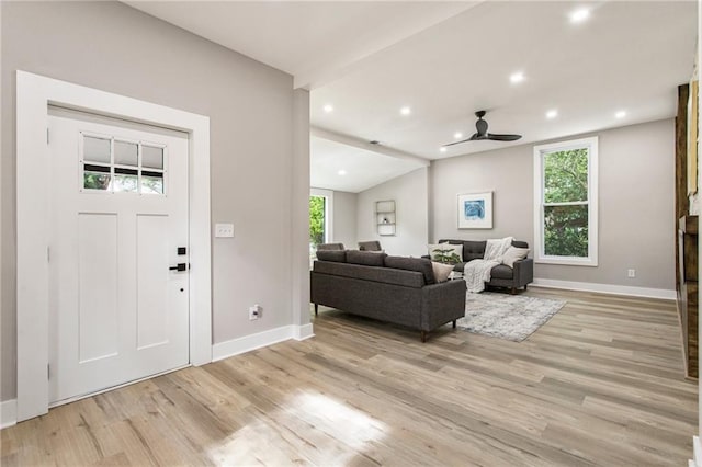 entryway featuring lofted ceiling, ceiling fan, and light wood-type flooring