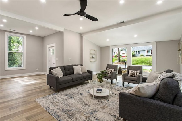 living room featuring light hardwood / wood-style flooring, lofted ceiling, and ceiling fan