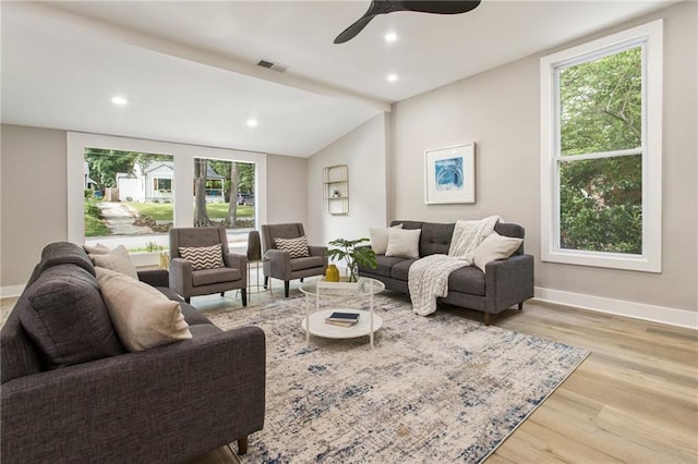 living room featuring light hardwood / wood-style flooring, lofted ceiling, ceiling fan, and plenty of natural light