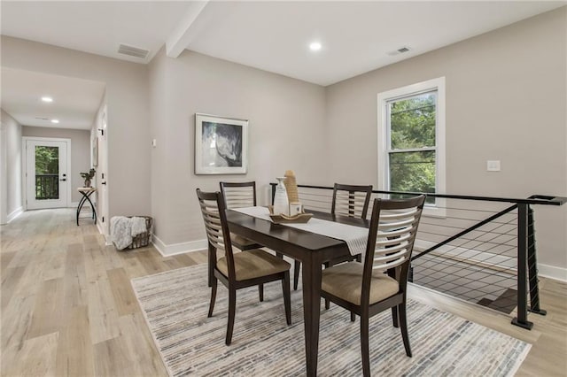 dining area featuring beamed ceiling and light hardwood / wood-style floors