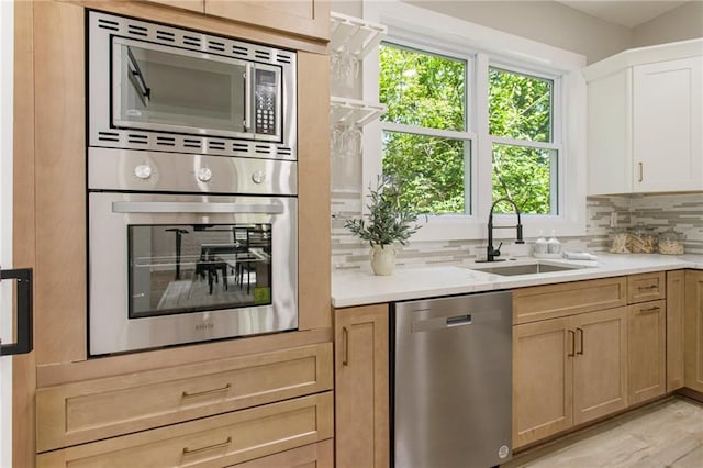 kitchen featuring appliances with stainless steel finishes, plenty of natural light, decorative backsplash, and sink