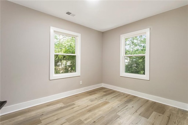 unfurnished room featuring light hardwood / wood-style floors and plenty of natural light