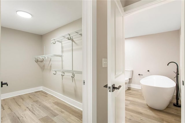 1510 Mims St SW, Atlanta, GA 30314 - bathroom featuring a soaking tub, toilet, wood finished floors, and baseboards