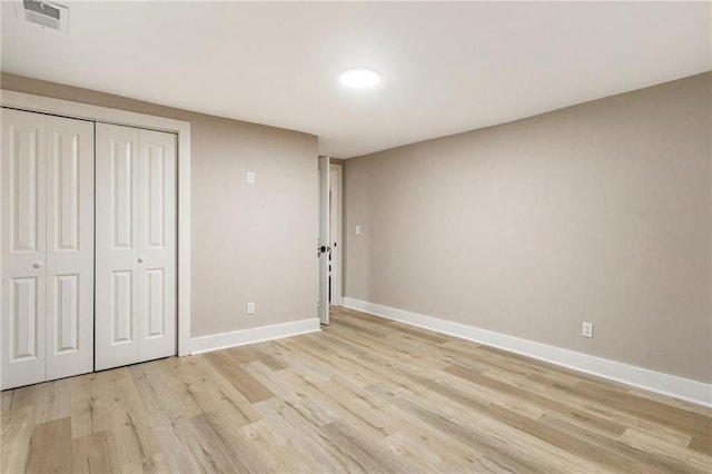 unfurnished bedroom featuring a closet and light wood-type flooring