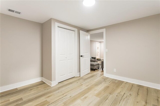 unfurnished bedroom featuring a closet and light wood-type flooring