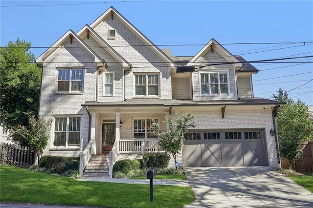 front facade with covered porch, a garage, and a front yard