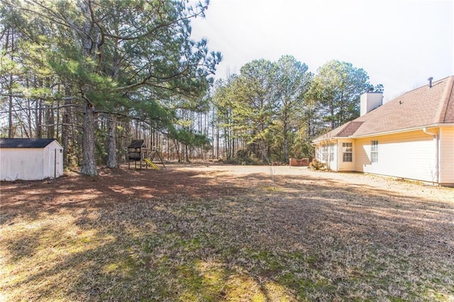 view of yard with a shed and a playground