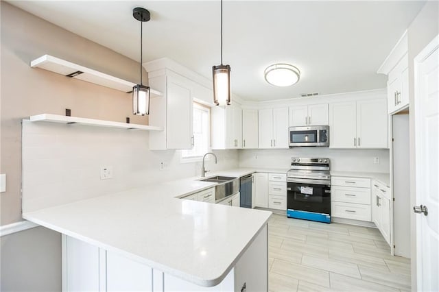 kitchen featuring sink, hanging light fixtures, appliances with stainless steel finishes, kitchen peninsula, and white cabinets