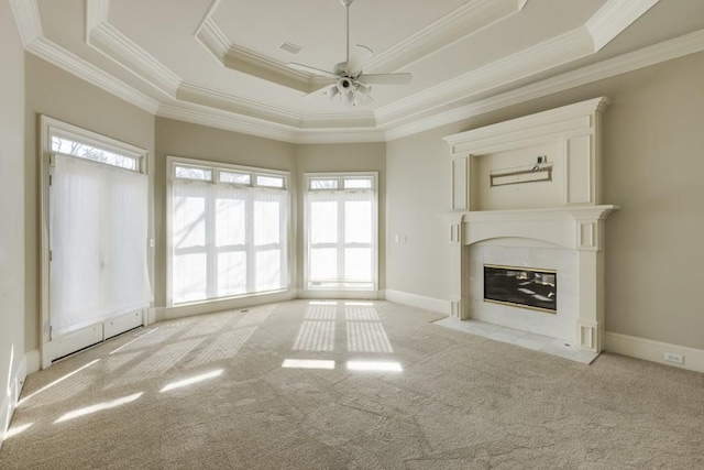 unfurnished living room with crown molding, plenty of natural light, a raised ceiling, and light carpet