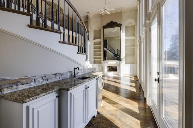 bar featuring white cabinetry, wood-type flooring, sink, dark stone countertops, and french doors