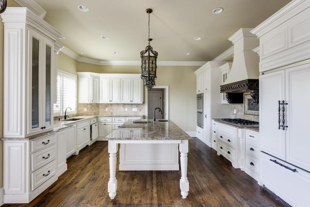 kitchen with a kitchen island with sink, white cabinetry, and a kitchen breakfast bar