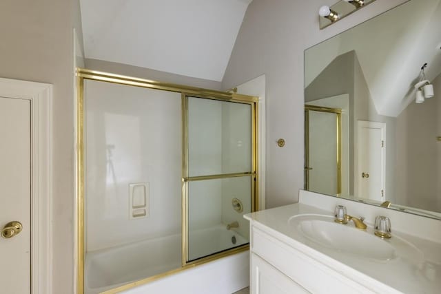 bathroom with vaulted ceiling, combined bath / shower with glass door, and vanity