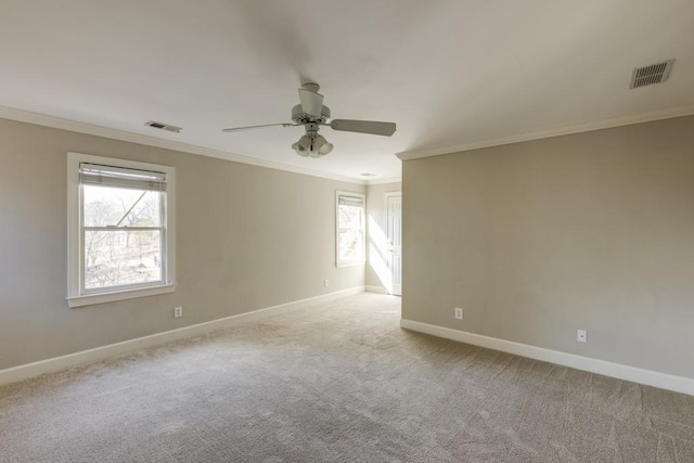 spare room with light carpet, ornamental molding, and ceiling fan